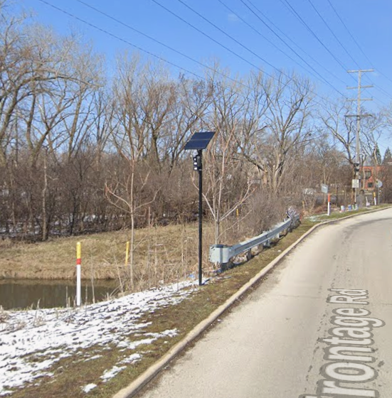 A Flock Safety camera mounted on a pole along a roadside